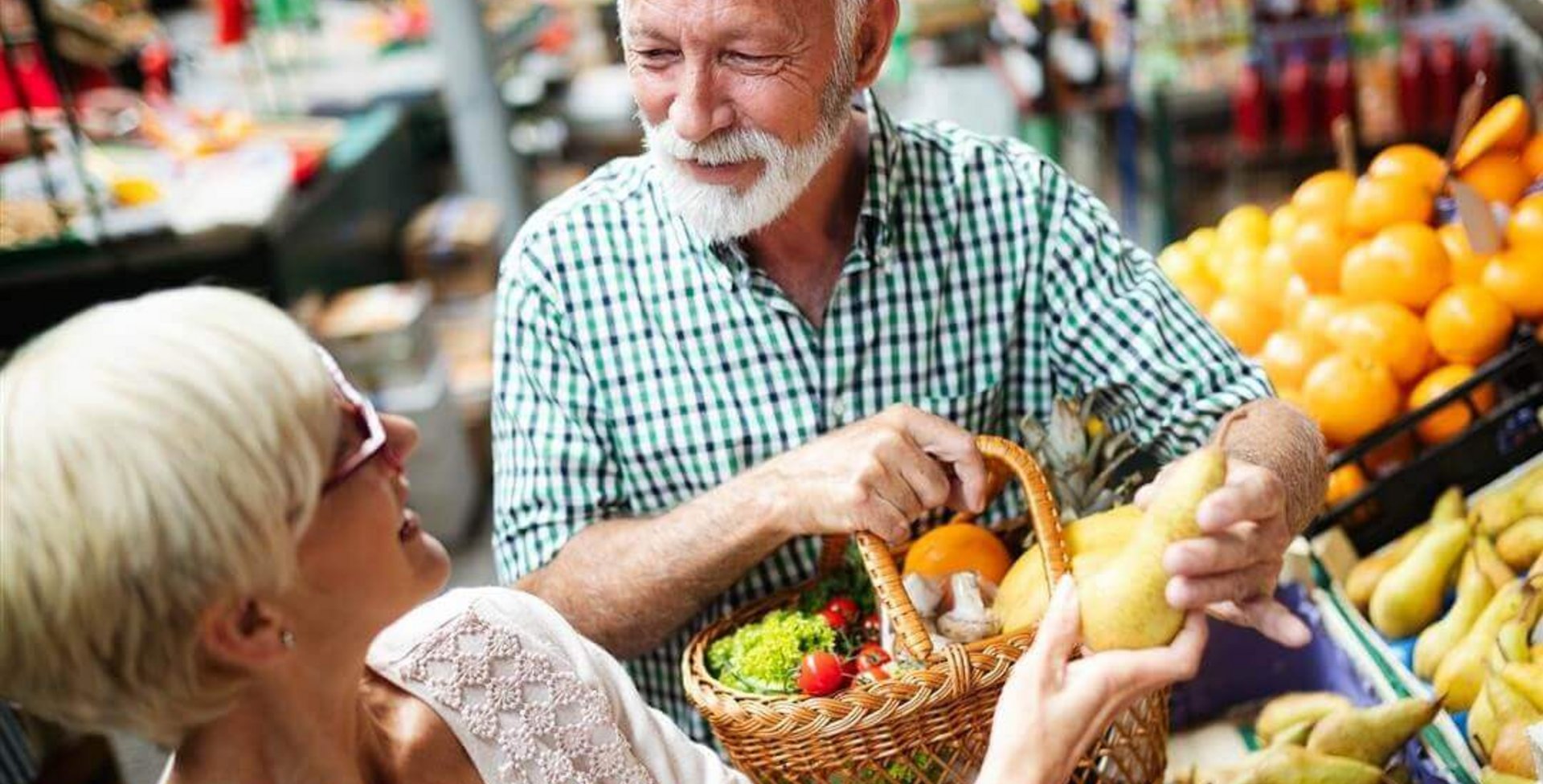 Auf dem Bild stehen ein Mann und eine Frau an einem Oststand am Markt. Sie wollen mit gesunder Ernährung gegen ihre Arthrose ankämpfen.