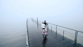 Zwei junge Frauen laufen über einen Steg am Ufer entlang. Sie tragen Run Performance Compression Socks von Bauerfeind, welche die Wadenmuskulatur durch gezielte Kompression unterstützen.