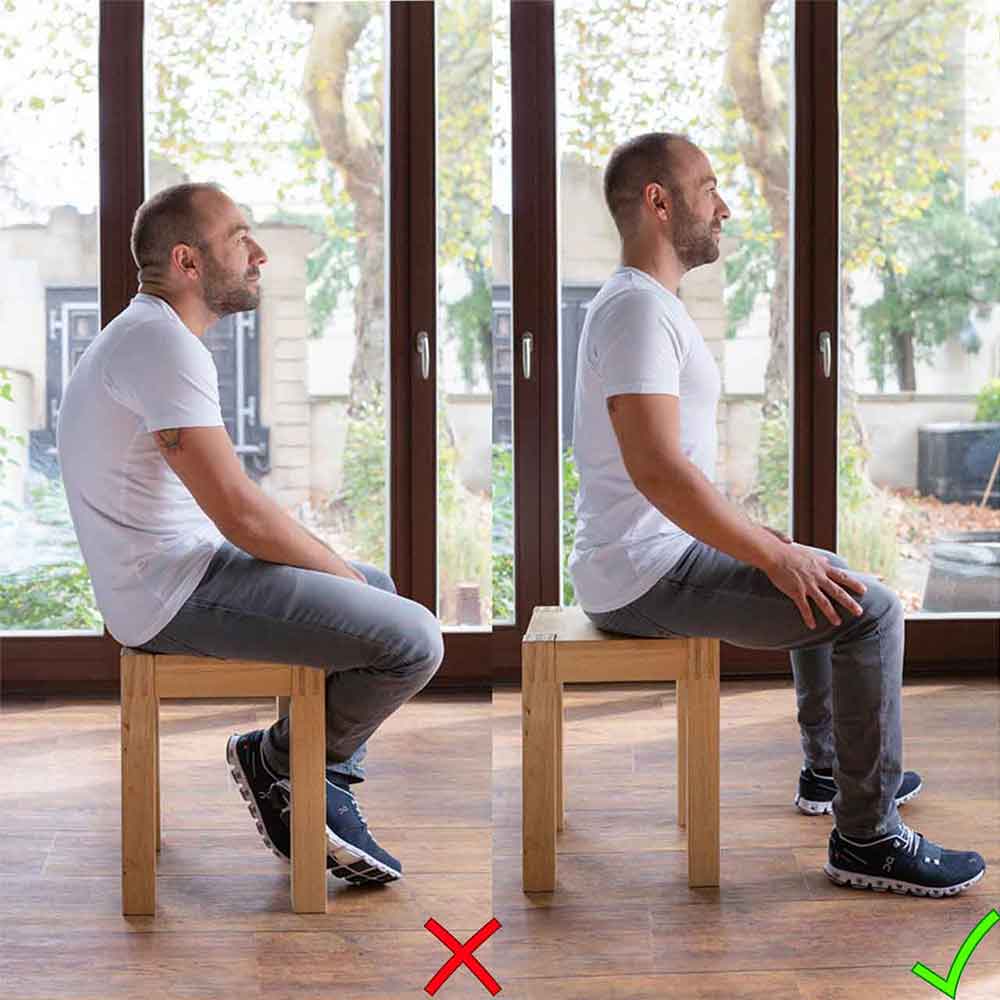 Ein Mann demonstriert, wie man richtig und falsch sitzt. Die Wirbelsäule sollte sich in ihrer physiologischen Form befinden. Das heißt, das Becken wird leicht nach vorne gekippt, wodurch sich der Brustkorb ein wenig anhebt.