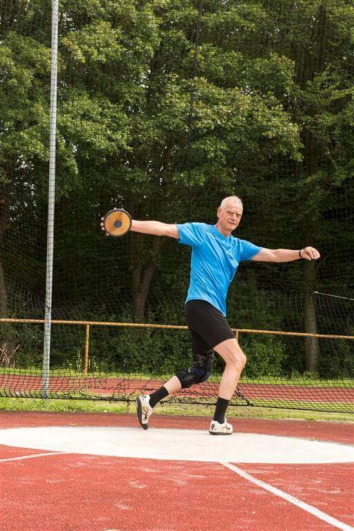 Das Bild zeigt den Sportler und Arthrose-Patienten Wilhelm Kraatz mit der Knieorthese GenuTrain OA beim Diskuswurf.