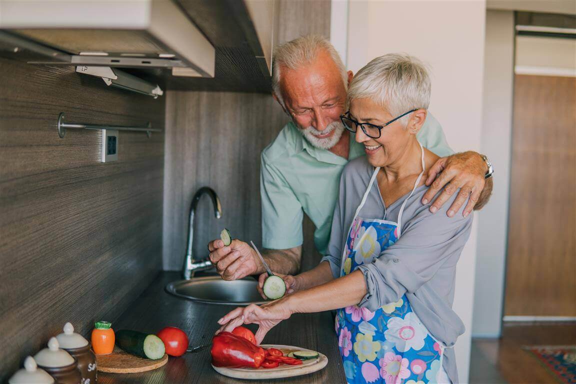 Das Bild zeigt, ein Mann und eine Frau, die zusammen kochen. Wir erklären, warum eine gesunde Ernährung bei Arthrose wichtig ist und wie diese sich gestalten sollte.
